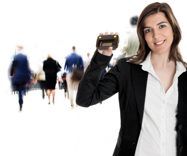 A young business woman holding up Convention Strategy Groups RFID Barcode Magstripe SMARTMOBILE reader.